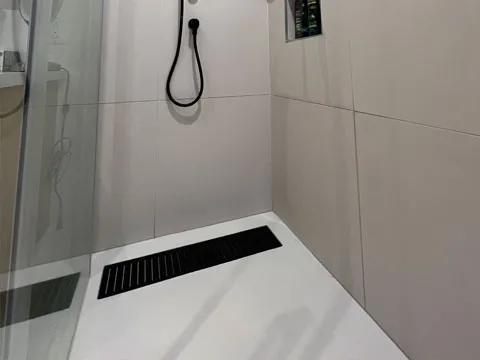 Base de douche en beton modele linea couleur blanc naturel et panneaux flutes gris perle naturel.